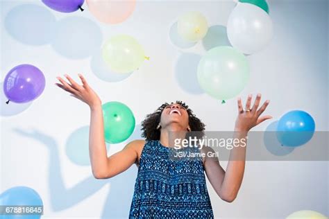 Black Woman Watching Falling Balloons Photo Getty Images
