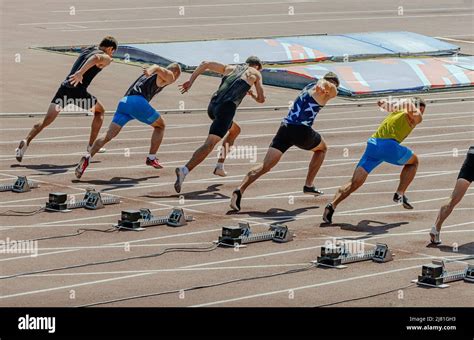 Man Athletes Starting Running In 100m Sprint Race Stock Photo Alamy