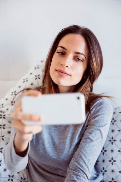 Free Photo Young Woman Posing For Selfie In Bed