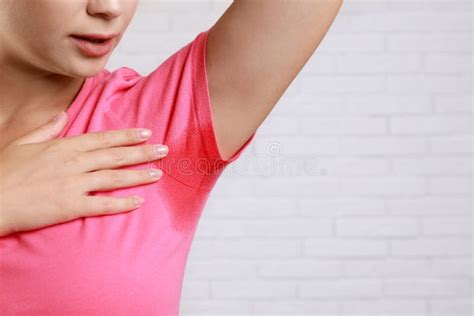 Young Woman With Sweat Stain On Her Clothes Against Wall Closeup