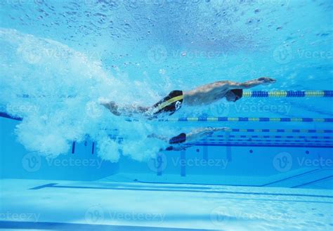 Underwater Shot Of Three Male Athletes Racing In Swimming Pool 746365