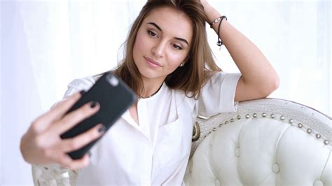 Young Girl Taking A Selfie Sitting On The Sofa Young Brunette Girl