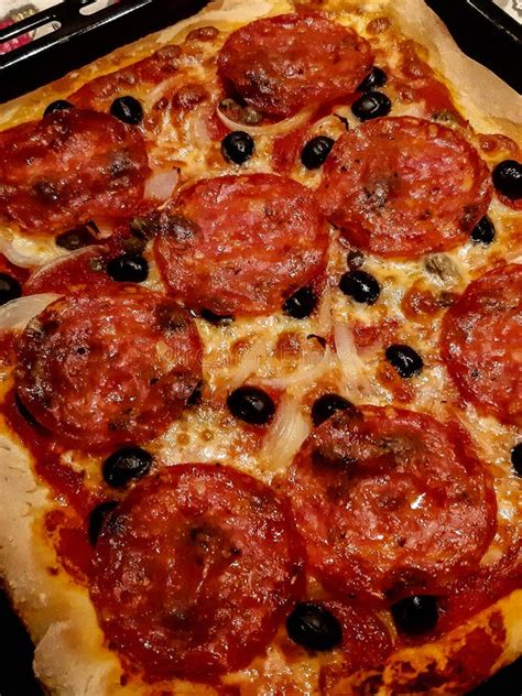 Homemade Pizza With Spicy Salami Black Olives Tomatoes And Mozzarella