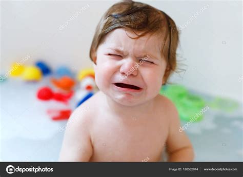 Cute Adorable Sad Baby Girl Taking Foamy Bath In Bathtub Crying