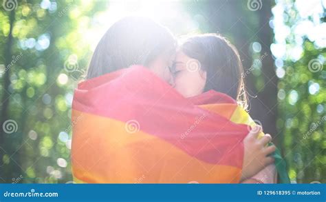 lesbische die minnaars in het kussen de tederheid en de liefde van de regenboogvlag worden