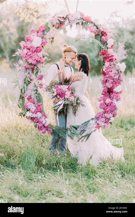 The Close Up Portrait Of The Smiling Newlyweds Holding The Bouquets Of