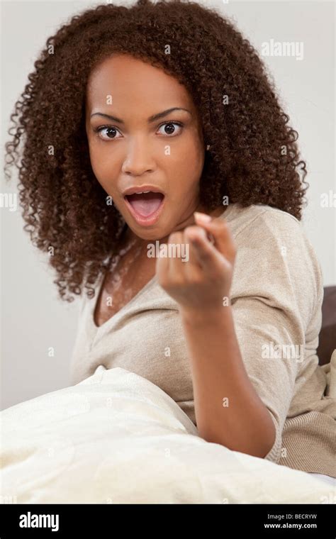 A Beautiful Mixed Race African American Girl Looking Shocked Surprised And Pointing At The