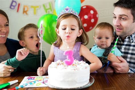 Family with three children (2-3, 4-5) celebrating birthday ...