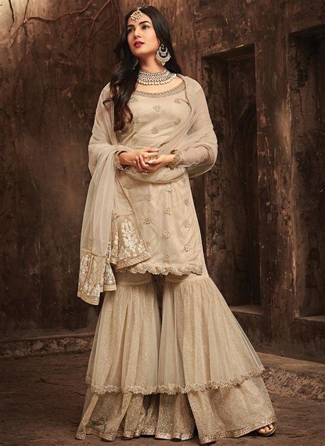 A Stunning Beige Sonal Chouhan Sharara Style Maisha Suit Net Top With Santoon Inner And Santoon