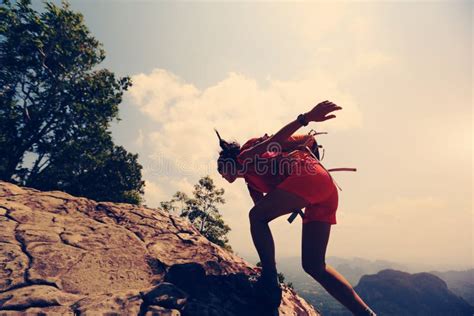 Asian Woman Hiker Climbing Rock On Mountain Peak Cliff Stock Image