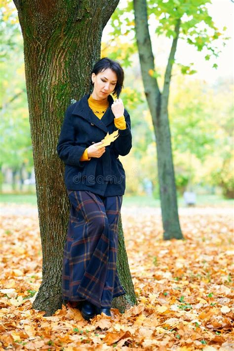 Beautiful Woman Posing With Yellow Leaves In Autumn City Park Fall