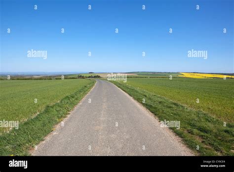 An English Agricultural Landscape With A Quiet Country Road Through The