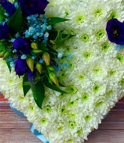 Blue and white coffin spray, blue delphinium, white roses, white lily's, casket spray www.thefloralartstudio.co.uk. Blue and White Heart - Funeral Flowers Reading