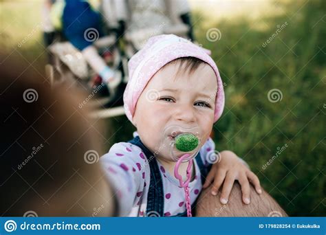 Funny Little Girl With A Pacifier In Her Mouth Stock Photo