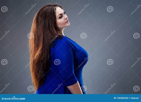 Brunette Plus Size Fashion Model In Blue Dress Fat Woman With Long Smooth Hair On Gray