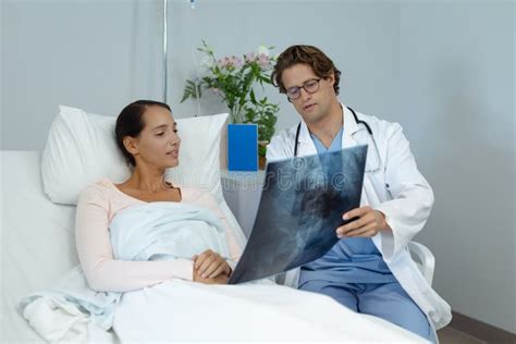 Male Doctor Interacting With Female Patient In The Ward Stock Image