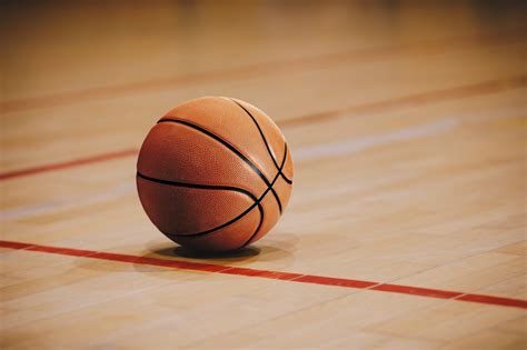 Classic Basketball On Wooden Court Floor Close Up With Blurred Arena In