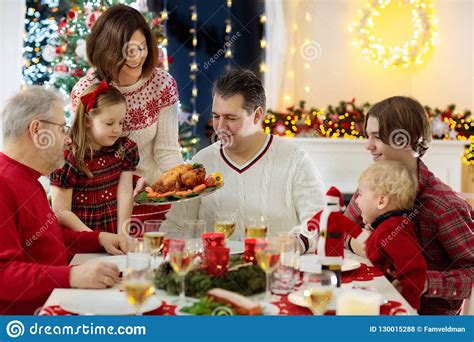 60+ creative christmas dinner ideas that are sure to steal the show. Family With Kids Having Christmas Dinner At Tree Stock Photo - Image of celebration, candle ...