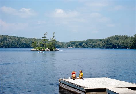 Kids Sit On A Dock On A Lake In Summer Del Colaborador De Stocksy