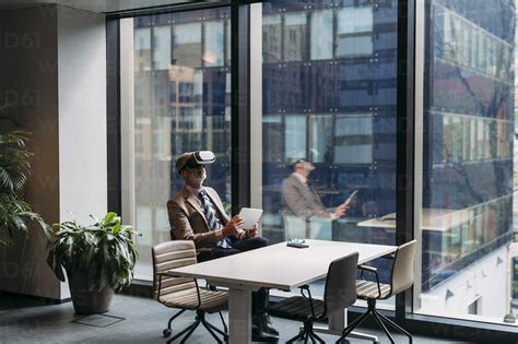 Geschäftsmann Mit Virtual Reality Simulator Sitzt Auf Einem Stuhl Am Fenster Im Büro