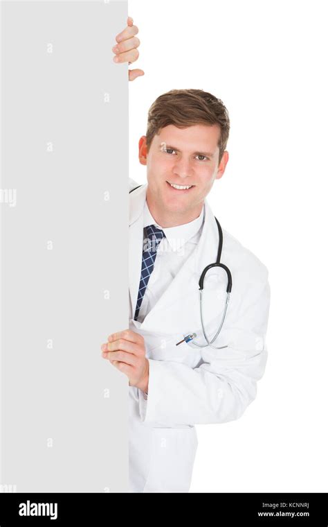 Happy Male Doctor Holding Blank Placard Over White Background Stock