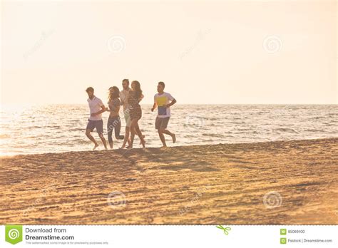 Happy Young People Group Have Fun White Running And Jumping On Beach At