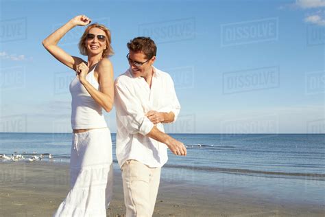 Caucasian Couple Dancing On Beach Stock Photo Dissolve