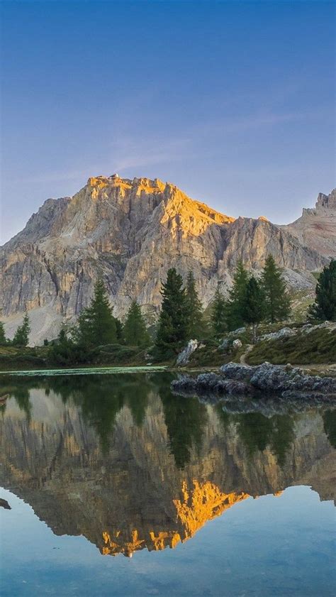 The Mountain Is Reflected In The Still Water On The Lakes Surface As
