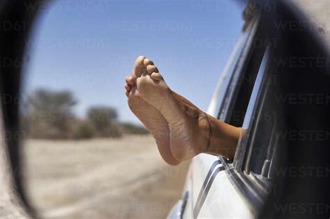 Woman S Feet Leaning Out Of The Car Window Stock Photo