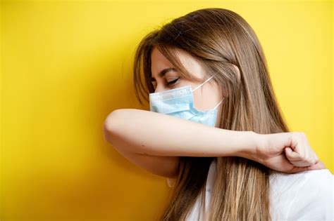 Premium Photo Woman Coughing In Elbow Wearing Mask