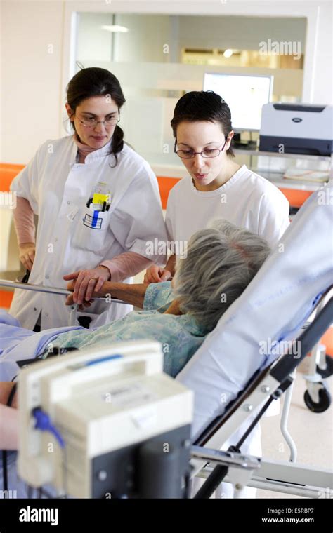 Doctor And Auxiliary Nurse Talking With Elderly Patient Emergency