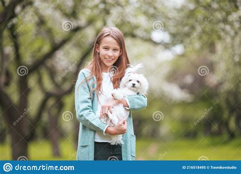 Little Smiling Girl Playing And Hugging Puppy In The Park Stock Image