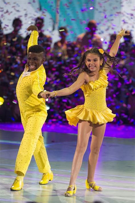 Two People In Yellow Outfits Are Dancing On The Dance Floor With Confetti All Around Them