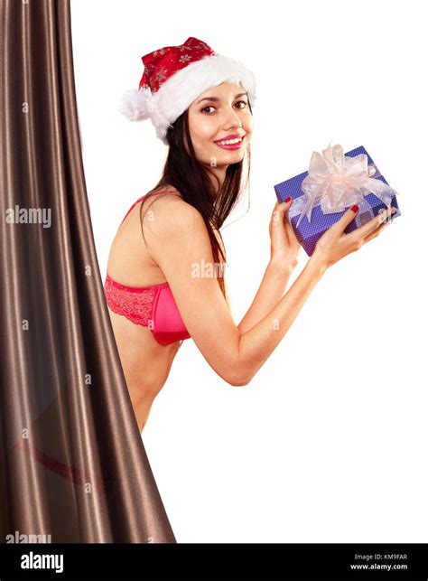 Beautiful And Sexy Woman With Gift Wearing Santa Clause Costume Hides Behind A Curtain Stock