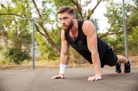 Attractive Bearded Sportsman Doing Push Ups Outdoors Stock Photo