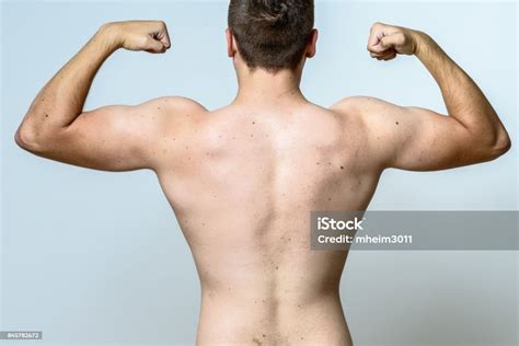 Fit Muscular Young Man Flexing His Muscles Stock Photo Download Image