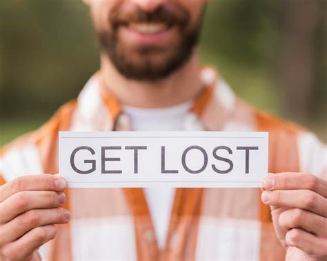 Smiley Defocused Man Holding Get Lost Sign Foto Gratis