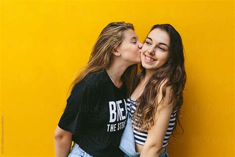 Teen Girls Kissing Over Yellow Background By Victor Torres Student