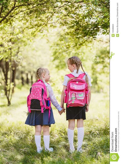 Girls In School Uniform And With Backpacks Stand Back