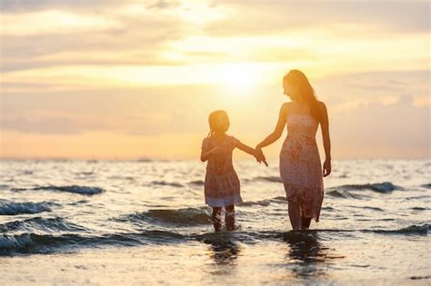 Madre E Hija Se Divierten Caminando Y Jugando En La Playa Al Atardecer