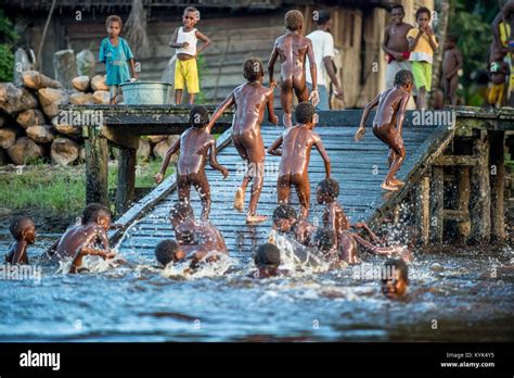Noisy Fun Kids Children Of The Tribe Of Asmat People Bathe And Swim In