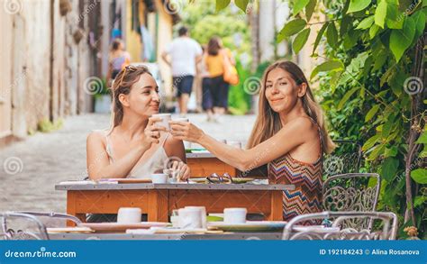 Two Happy Smiling Blond Hair Women Drinking Something In Italian Restaurant Or Cafe Stock Image
