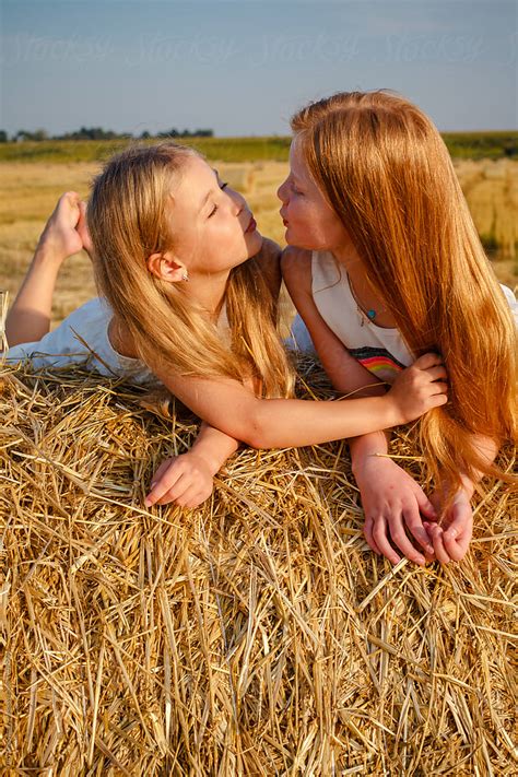 Portrait Of Kissing Girls On The Hay By Stocksy Contributor Yury Goryanoy Stocksy
