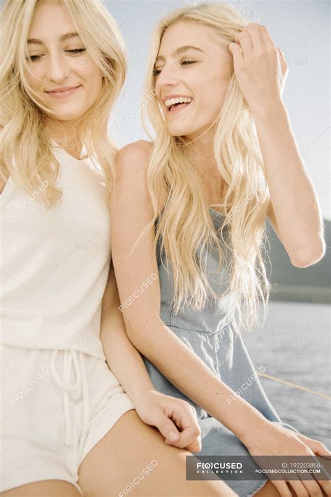 Portrait Of Two Blonde Sisters Laughing On Sailboat On Lake — Non