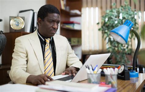 African American Office Employee Focused On Working With Laptop Stock