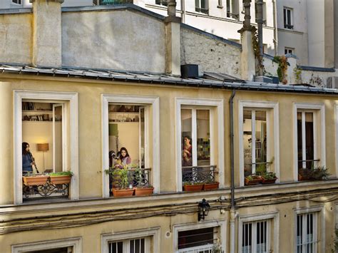 voyeuristic photos capture intimate scenes through apartment windows in paris