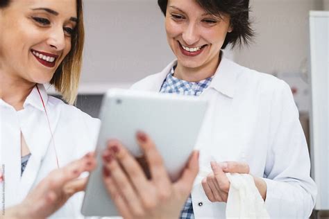 Two Female Doctors Using Tablet While Working Del Colaborador De