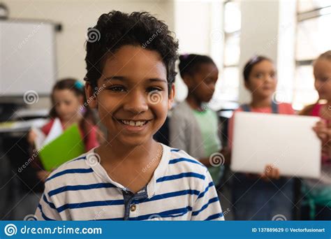 Happy Schoolboy Looking At Camera In Classroom Of Elementary School