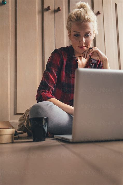 Blonde Woman Sitting On The Floor And Working On Her Laptop Del Colaborador De Stocksy Lumina