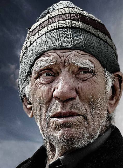 An Old Man Wearing A Knitted Hat And Looking At The Camera While
